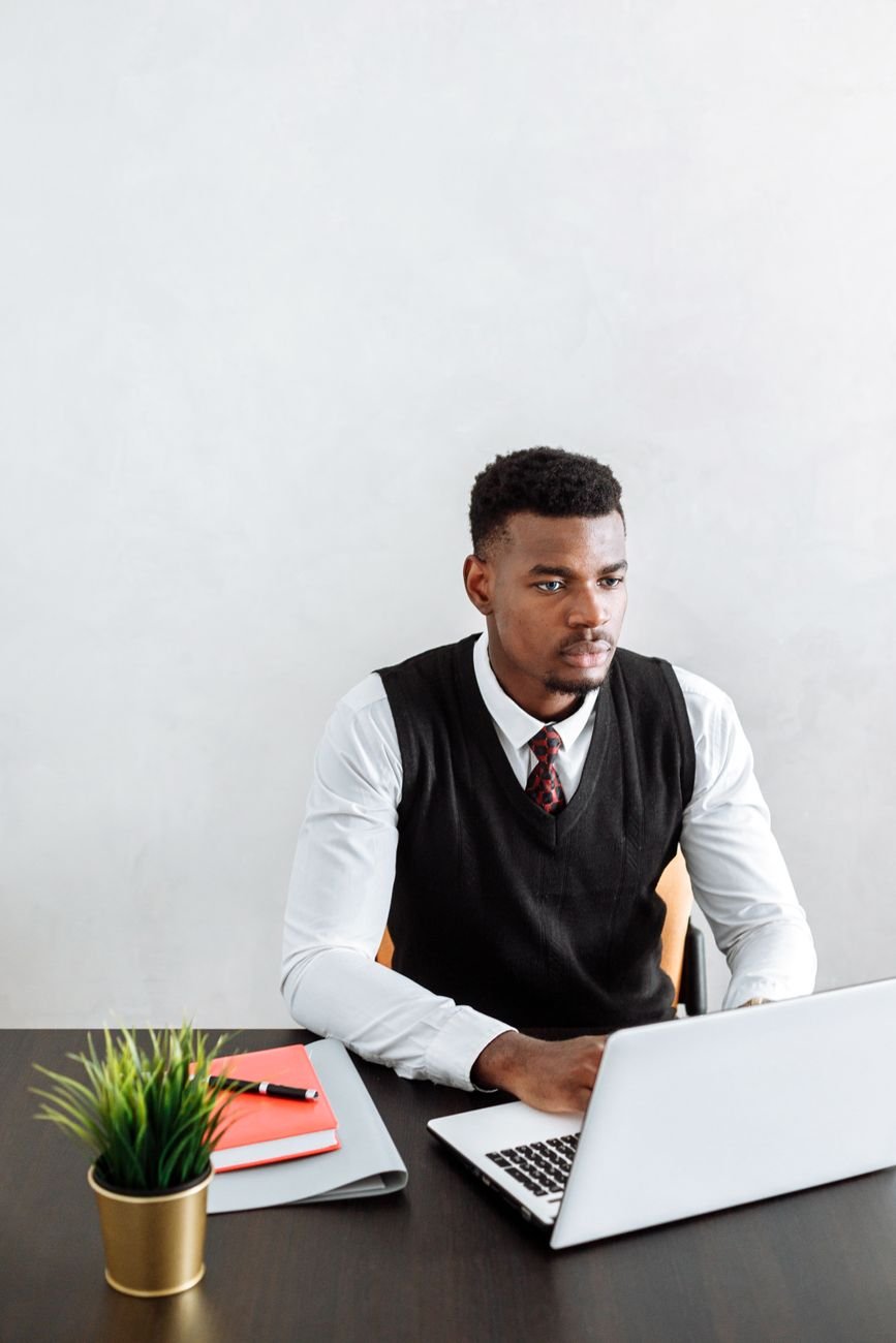 Professional businessman working diligently on a laptop at a modern desk.